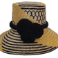 Handmade Wayuu straw hat with black pompoms and bold yellow weave.Artisan straw boho hat with bold black pompoms and geometric design

