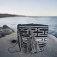 Black and white handmade Wayuu bag with bold geometric crochet pattern and tassels.