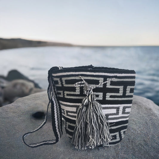 Black and white handmade Wayuu bag with bold geometric crochet pattern and tassels.