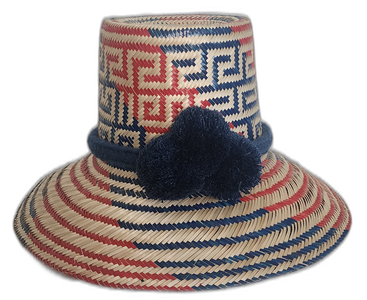 Boho Straw Hat with navy pompom, handmade by Wayuu artisans in red, blue, and natural straw