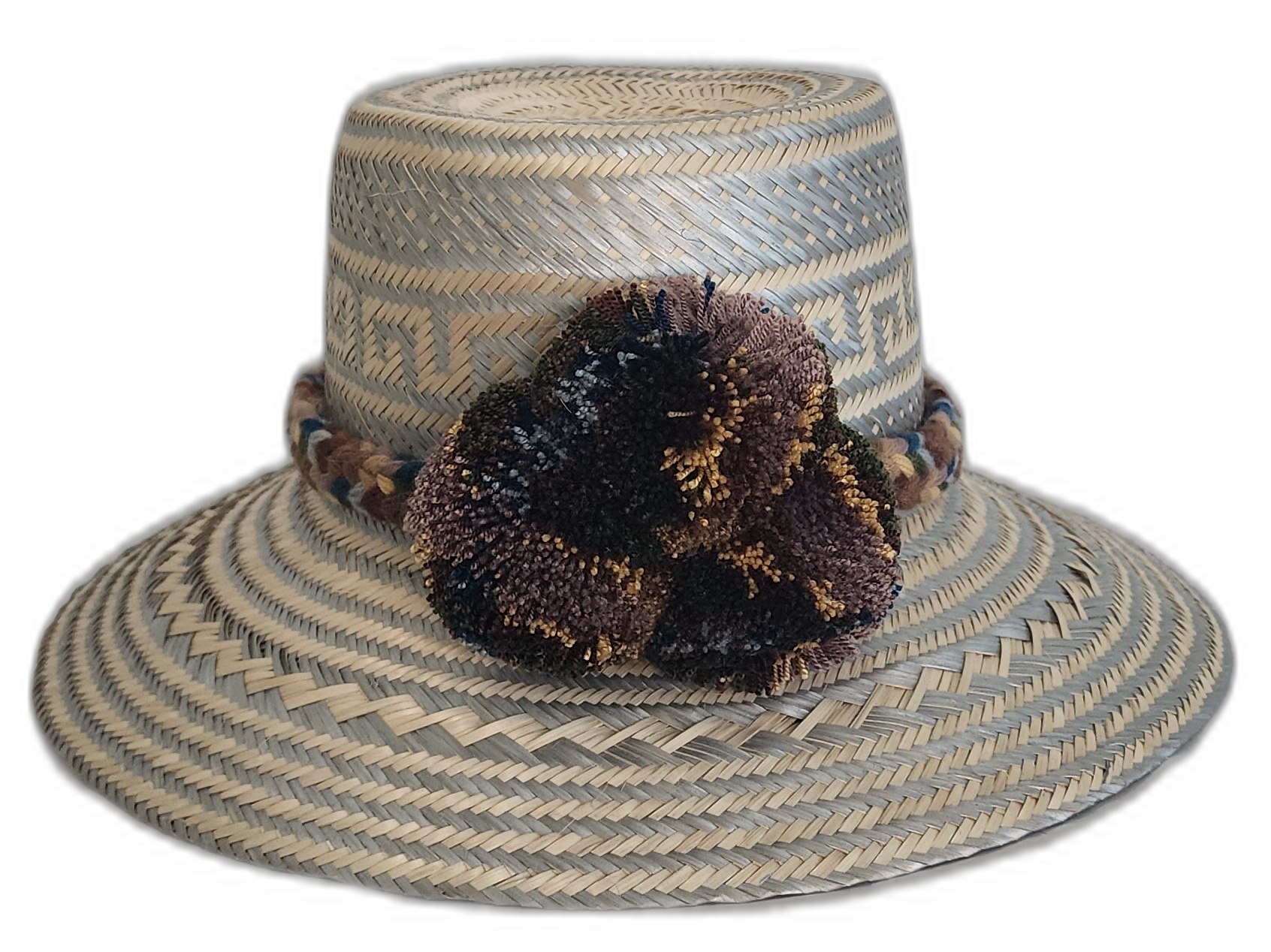 Handmade Wayuu straw hat in earth tones with soft pompom accents

