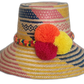 Handmade Wayuu boho straw hat with pink, yellow, and blue woven pattern and bold yellow, fuchsia, and orange pompoms.