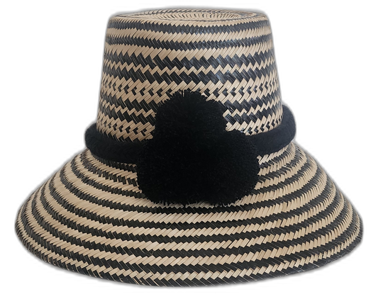 Handmade Wayuu straw hat in black and natural with decorative pompoms