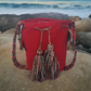 Boho-chic handmade red Wayuu crochet bag with artisan tassels and colorful chevron strap — bold and unique.