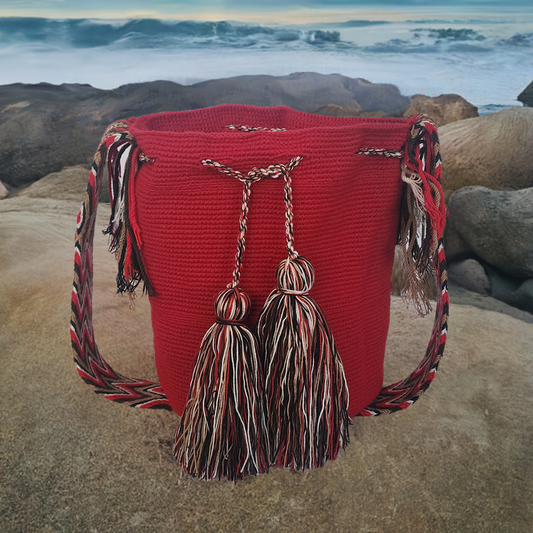 Boho-chic handmade red Wayuu crochet bag with artisan tassels and colorful chevron strap — bold and unique.