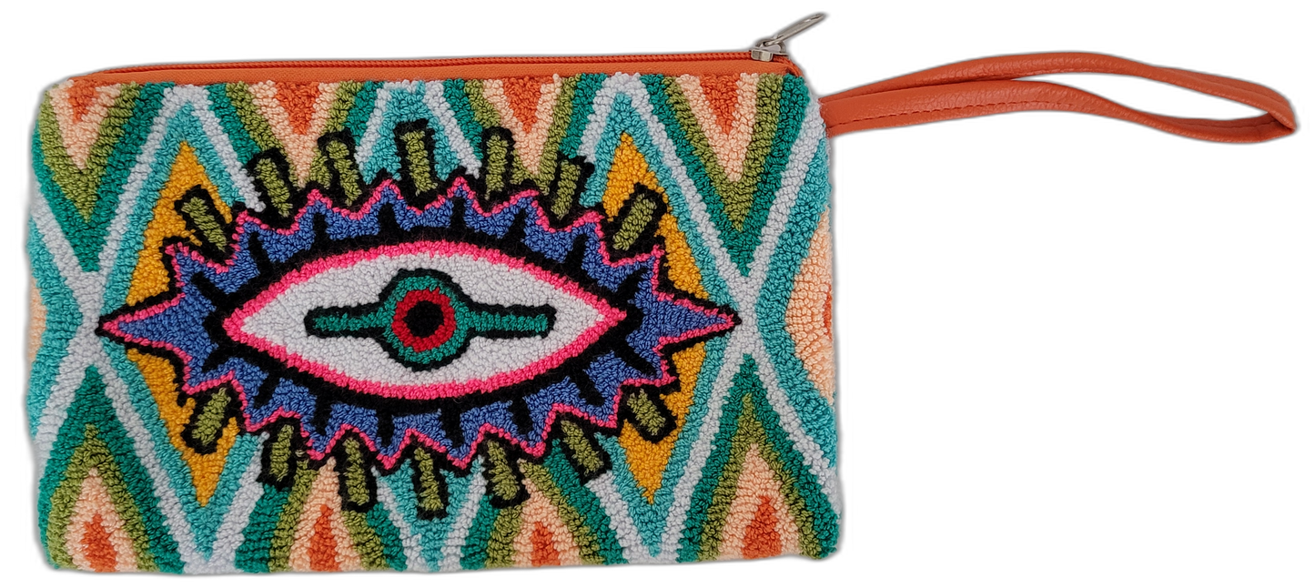 The Reign clutch is a bold punch needle Wayuu creation with vibrant colors and eye motif. Handmade, colorful, and fully lined for boho chic lovers.

