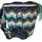 Boho chick bag featuring large pom-poms, crystal details, and artisan strap.