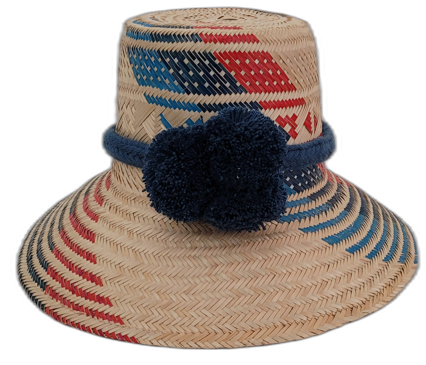 Sage handmade Wayuu straw hat with red and navy geometric weave and navy pompoms

