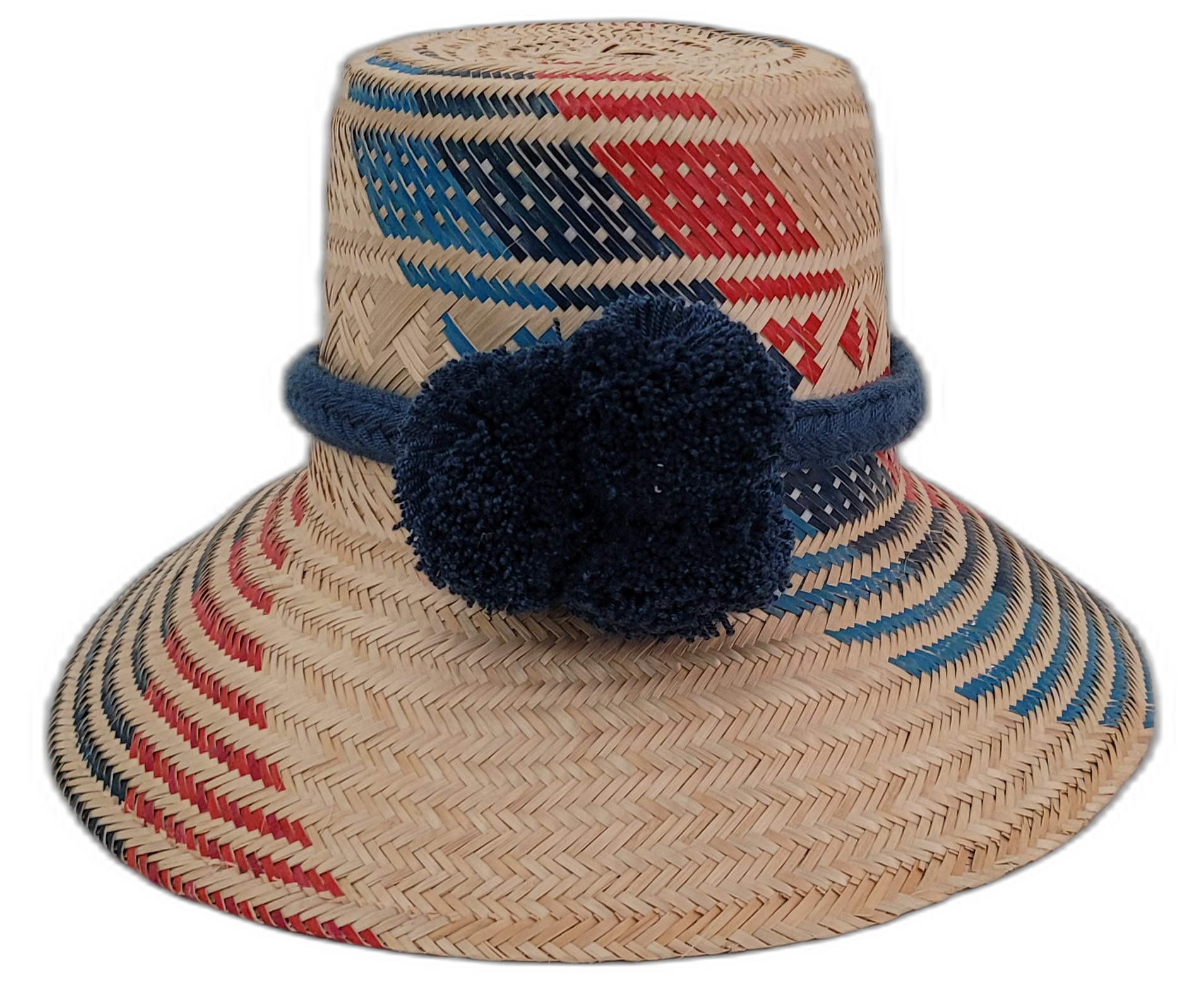 Sage handmade Wayuu straw hat with red and navy geometric weave and navy pompoms

