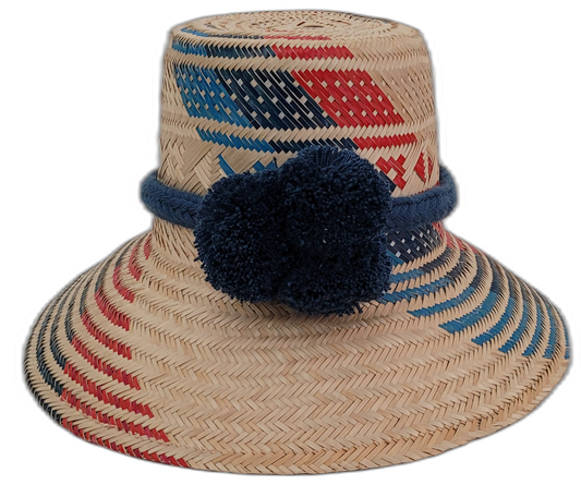 Sage handmade Wayuu straw hat with red and navy geometric weave and navy pompoms

