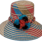 Selena handmade Wayuu hat with natural, red, blue, and black palm weave and pompoms

