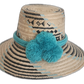 Handmade Wayuu straw hat with black and sky blue woven pattern and three light blue pompoms. Bohemian artisan hat featuring black and turquoise tribal patterns

