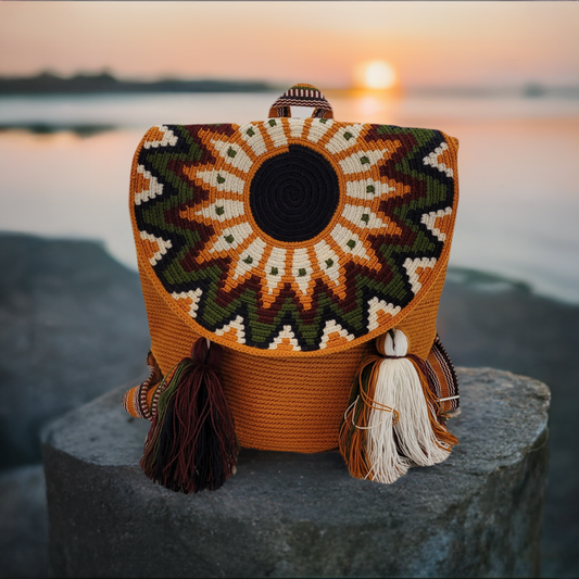 Handmade Wayuu backpack with sunburst pattern flap in earth tones.