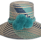 Boho Straw Hat in turquoise and navy with large pompoms, handmade by Wayuu artisans