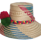 Boho chic straw hat crafted by Wayuu artisans, featuring bold woven patterns and pompom trim.

