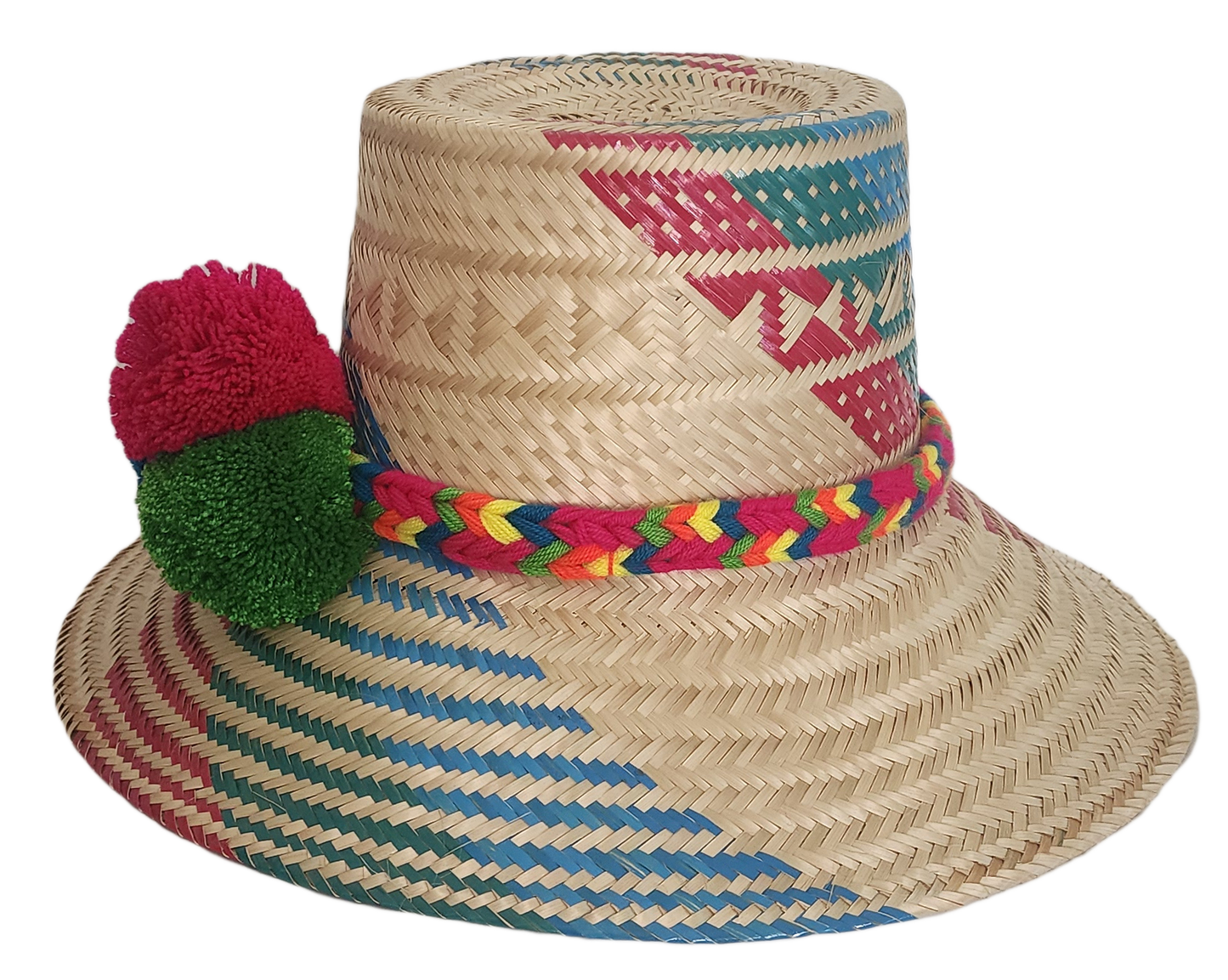 Boho chic straw hat crafted by Wayuu artisans, featuring bold woven patterns and pompom trim.

