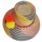 One-of-a-kind Wayuu straw hat with fuchsia, yellow, and orange pompoms on a bold pink-yellow design.
