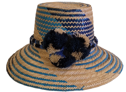 Handmade Wayuu straw hat with blue and natural palm weave, featuring navy pompoms.
