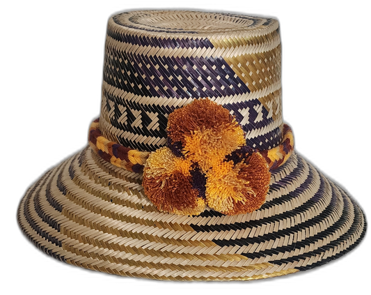 Handmade Wayuu straw hat with navy and gold tribal patterns and pompoms