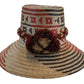 Handmade bohemian Wayuu straw hat with navy, red, and beige weave and brown pompoms

