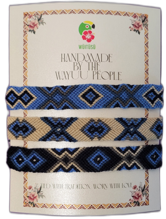 Handmade Wayuu friendship bracelets in blue, black, and cream tones.