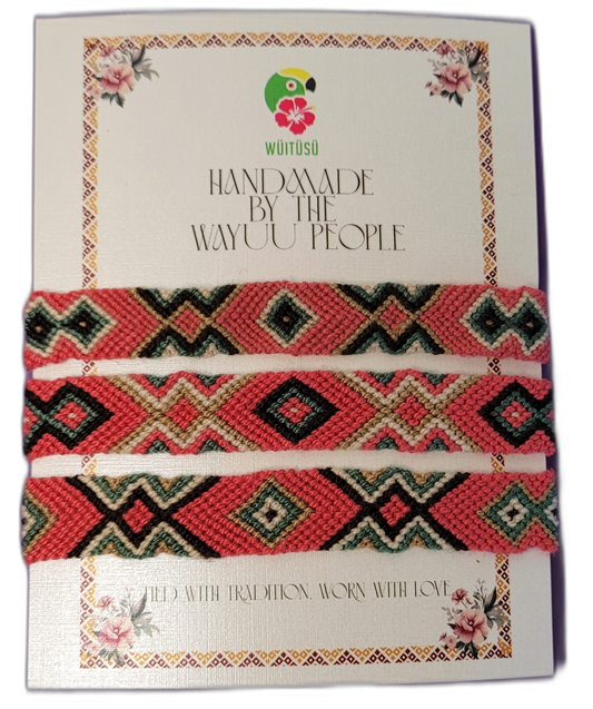 Handmade Wayuu friendship bracelets in coral, green, and cream.