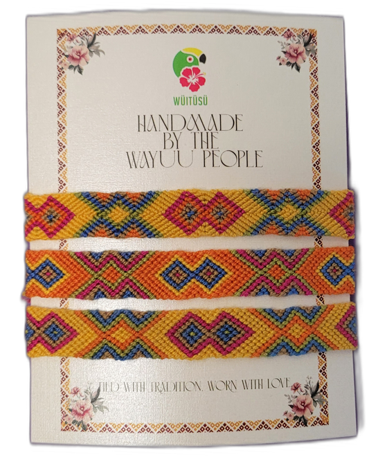Handmade Wayuu friendship bracelets in yellow, orange, and blue tones.