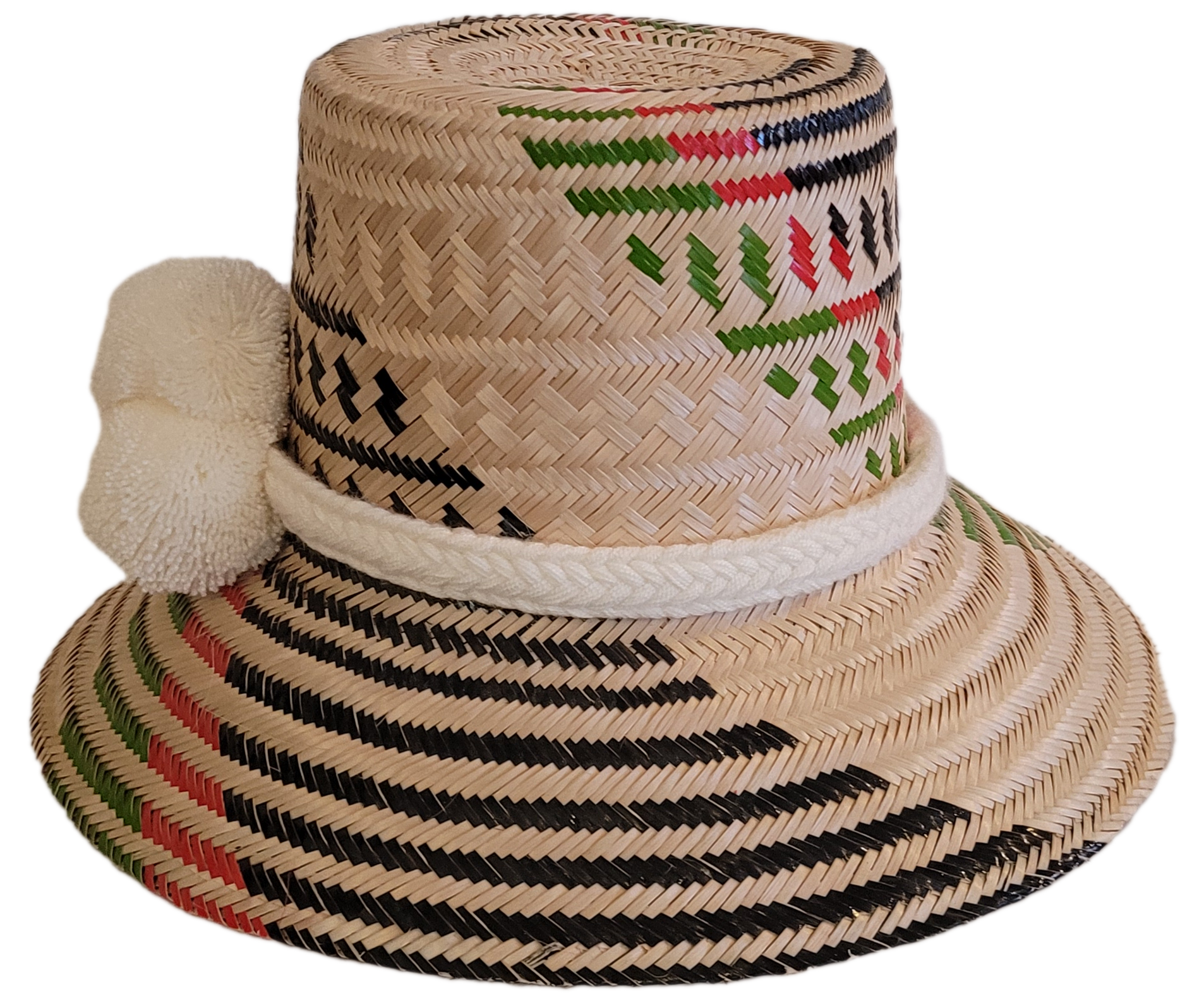 Boho chick straw hat featuring white pompoms and vibrant Wayuu patterns in black, green, and red.