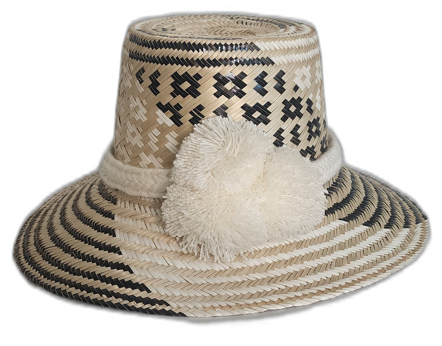 Handmade Wayuu boho straw hat with black and natural geometric weaving and ivory pompoms.