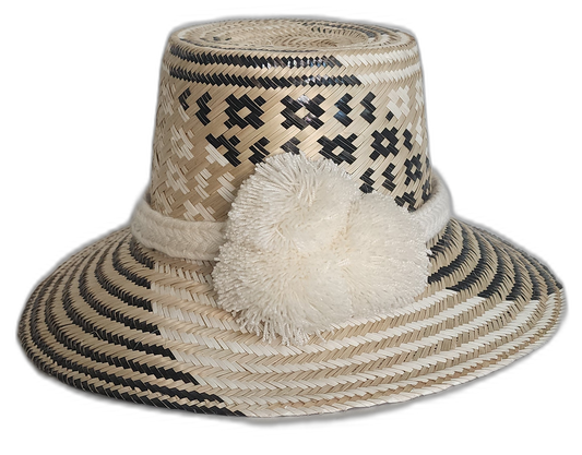 Handmade Wayuu boho straw hat with black and natural geometric weaving and ivory pompoms.