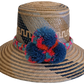Handmade Wayuu straw hat with blue, coral, and teal pompoms.