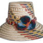 Handmade Wayuu straw hat with woven red, mustard, navy, and teal patterns and multicolor pompoms.