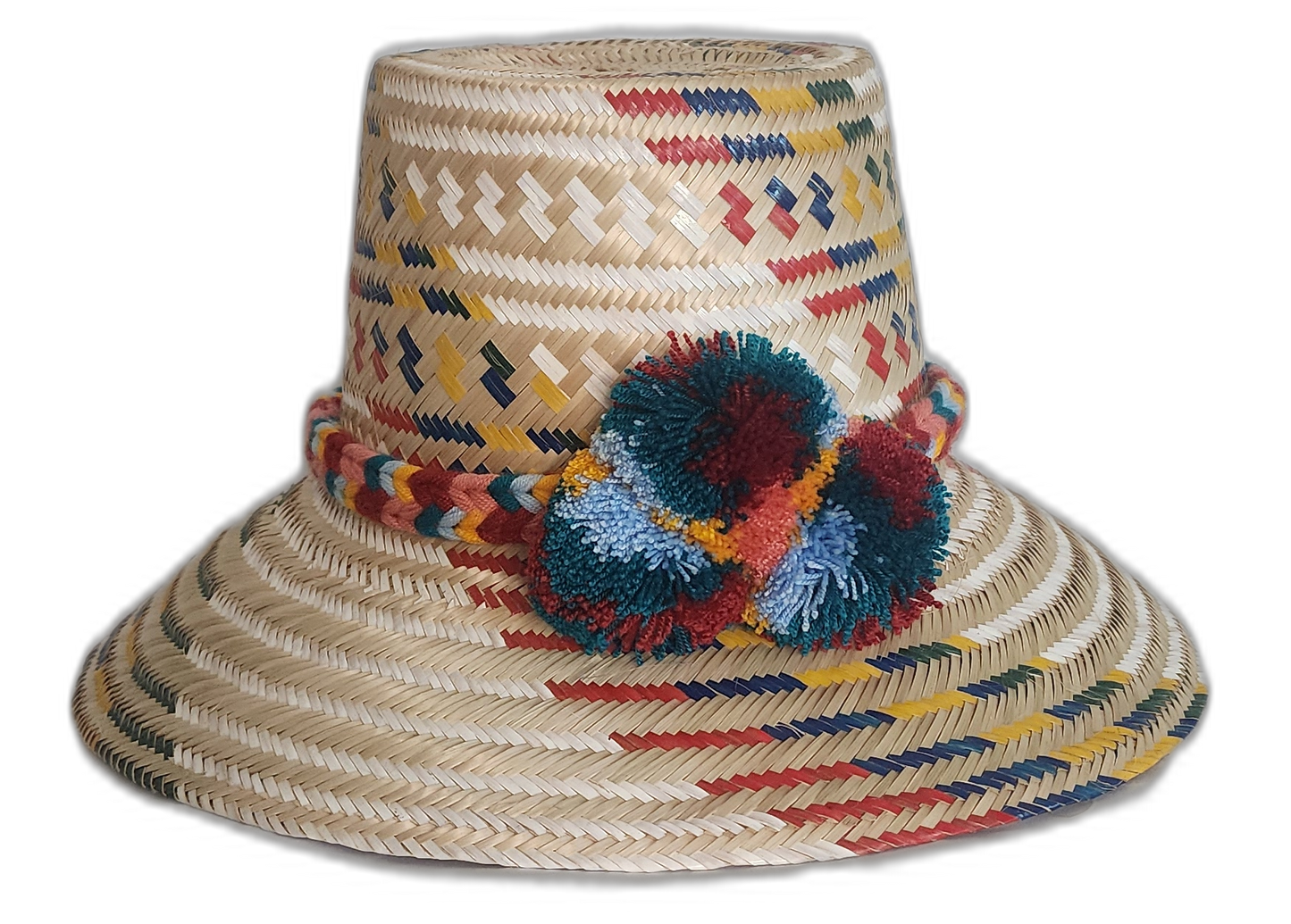 Handmade Wayuu straw hat with woven red, mustard, navy, and teal patterns and multicolor pompoms.