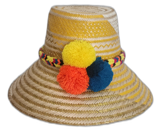 Handmade Wayuu straw hat with yellow stripes and yellow, blue, and orange pompoms.Bohemian straw sun hat handcrafted by Wayuu artisans in yellow tones

