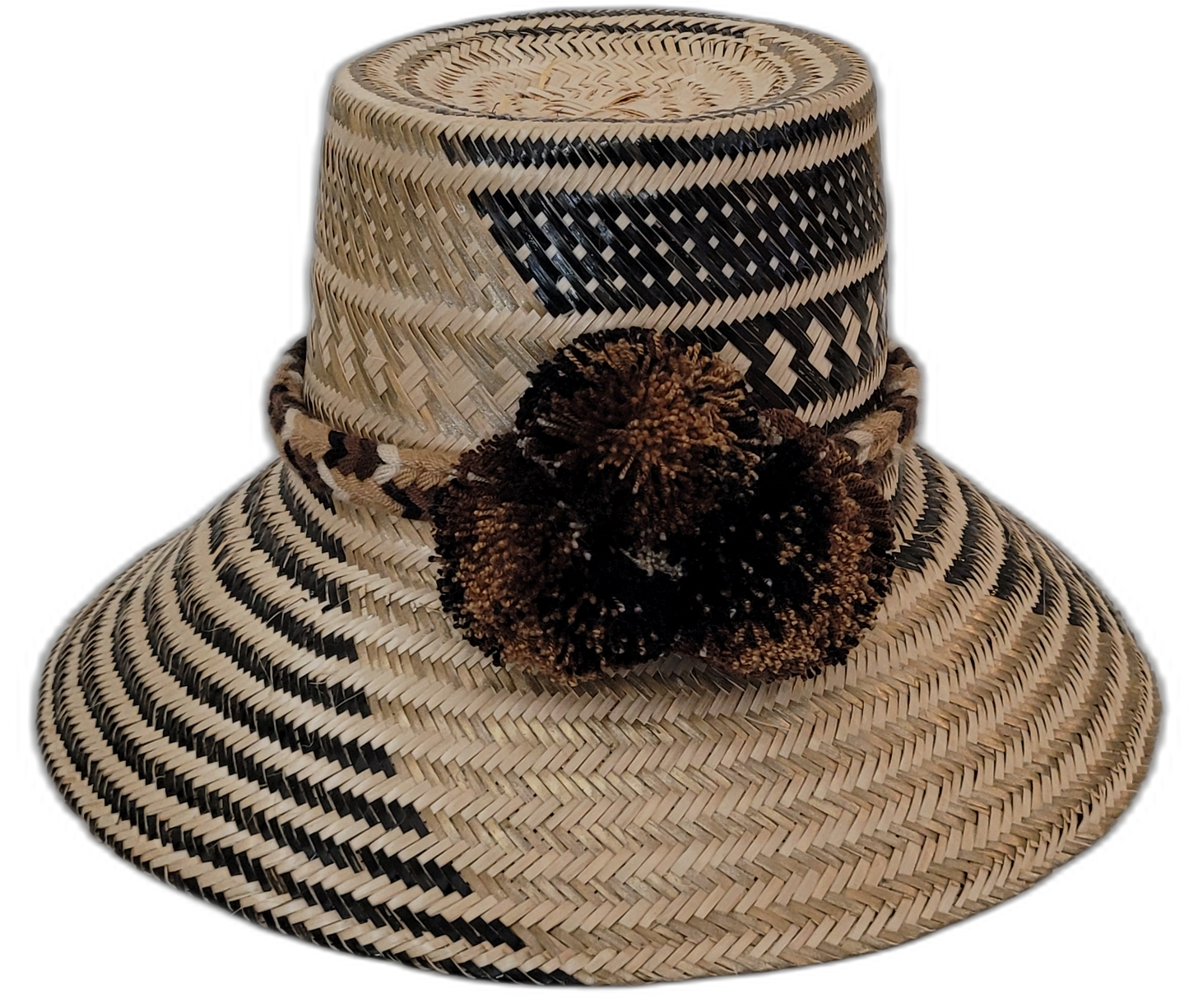 Zuri handmade Wayuu straw hat with black and brown weave and earth-toned pompoms

